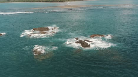 Drone-aerial-of-waves-crashing-on-sea-stacks-in-the-ocean-of-Costa-Rica,-Whale's-Tail