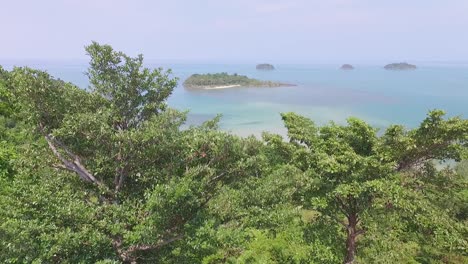 Tropical-Koh-Chang-woodland-vegetation-rising-aerial-view-overlooking-turquoise-ocean-coastline-islands