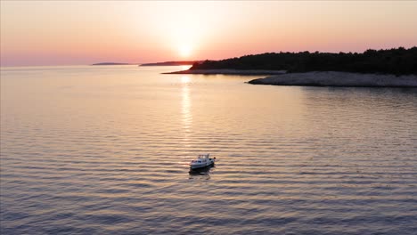 Luftaufnahme,-Die-Ein-Boot-Bei-Sonnenuntergang-Vor-Der-Küste-Der-Insel-Losinj,-Kroatien,-Umkreist