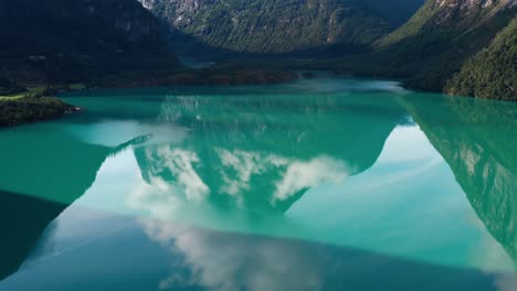 Lago-Transparente-Verde-Prístino-Entre-Montañas-Altas-En-Noruega-Con-Reflejo-De-Las-Montañas