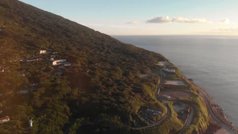 Aerial-drone-tilt-up-over-beautiful-Island-at-Sunset-next-to-ocean