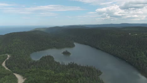 Frondoso-Bosque-Que-Rodea-El-Tranquilo-Lago-En-Saint-Anne-Des-Mont-Por-La-Península-De-Gaspe-En-Verano-En-Quebec,-Canadá