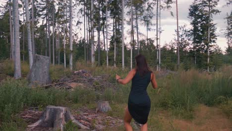 Wide-circle-pan-shot-of-attractive-young-girl-dancing-in-nature-woods-at-sunset