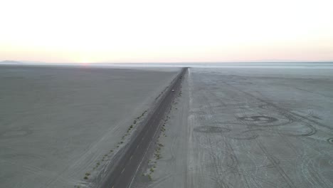 Twilight-Aerial-View-of-Straight-Road-in-Middle-of-Salt-Flats-Desert-Landscape