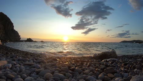 Zeitraffer-Eines-Sonnenaufgangs-Hinter-Den-Wolken-An-Einem-Steinigen-Strand-In-La-Costa-Brava,-Katalonien