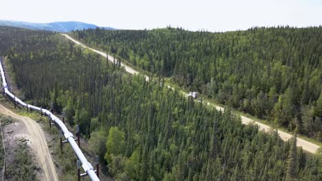 Alaska-Landscape---Car-Driving-on-Road-next-to-Pipeline,-Aerial-Tracking-View