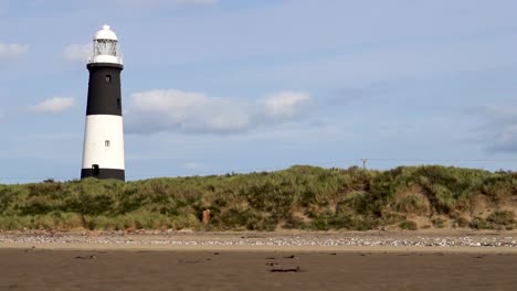 Composed-Gliding-Lighthouse-with-Bushes,-sand-and-sky-proportional