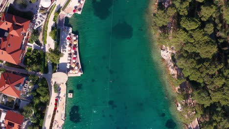 Top-down-Shot-Of-Beautiful-Lagoon-With-Bright-Blue-Water-In-A-Luxury-Resort-In-Island-Losinj,-Croatia---Travel-Destination---aerial