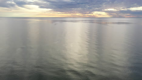 AERIAL:-Reveal-Shot-of-Majestic-Cloudy-Sky-Above-Baltic-Sea-on-a-Evening
