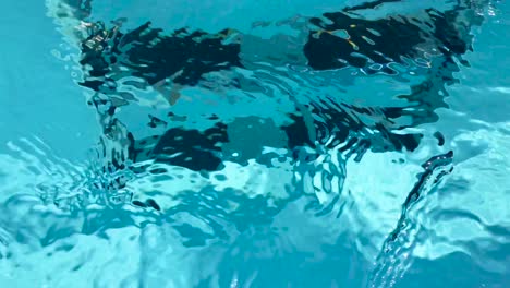Transparente-Nahaufnahme-Von-Schwimmbadleitern-Mit-Schwarzen-Stufen-Unter-Durchsichtigem,-Kristallklarem,-Gereinigtem-Wasser,-Das-In-4k-Flussabwärts-Fließt