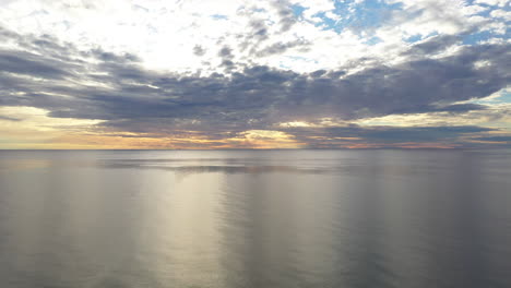AERIAL:-Ascending-Pedestal-Shot-of-Horizon-and-Cumulus-Cloudy-Sky-with-Calm-Baltic-Sea