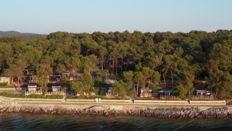 Aerial-low-shot-of-wooden-houses-in-a-camping-of-the-mediterranean-coast-of-Mali-Losinj
