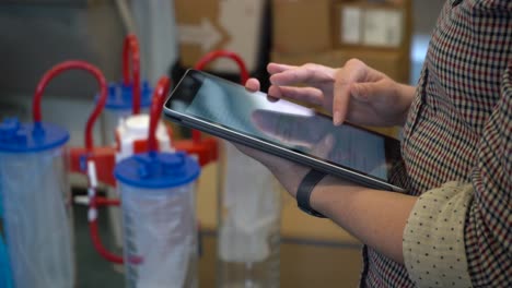 Delivery-woman-scrolling-on-computer-tablet-after-dropping-medical-equipment-and-medicines-to-the-health-sector