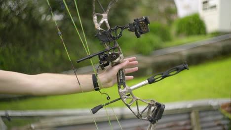 A-side-view-of-a-compound-bow-being-drawn-and-fired-with-a-very-shallow-depth-of-field