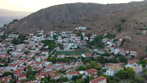 Aerial-drone-video-of-picturesque-port-and-main-village-of-Hydra-or-Ydra-island-with-beautiful-neoclassic-houses,-Saronic-gulf,-Greece