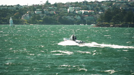 Small-recreational-speed-boat-traveling-through-choppy-water-in-bay,-slow-motion