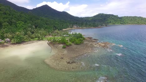 Aerial-dolly-shot-of-tropical-island-coastline-with-mangroves,palm-trees-and-beach-with-jungle-mountains-in-the-background