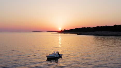 Luftaufnahme-Aus-Mittlerer-Entfernung,-Die-Bei-Sonnenuntergang-Vor-Der-Küste-Von-Losinj,-Kroatien,-Um-Ein-Boot-Kreist