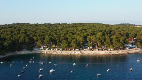 Aerial-shot-over-a-bay-full-of-anchored-boats-in-Mali-Losinj,-Croatia-on-a-bright-day