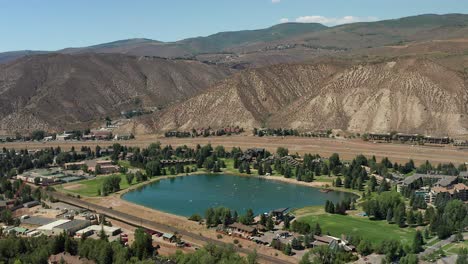 Aerial-footage-of-paddle-boarders-on-Benchmark-Lake-located-in-Avon,-Colorado