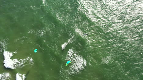 AERIAL:-Top-View-Shot-of-Surfers-Wakeboarding-In-Summer-on-a-Green-Colour-Baltic-Sea-Waves