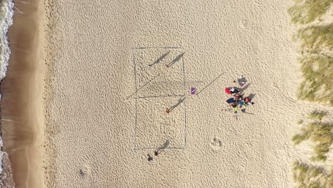 Luftaufnahme:-Volleyballspiel-Mit-Langen-Schatten-Von-Spielern-Auf-Einem-Sand