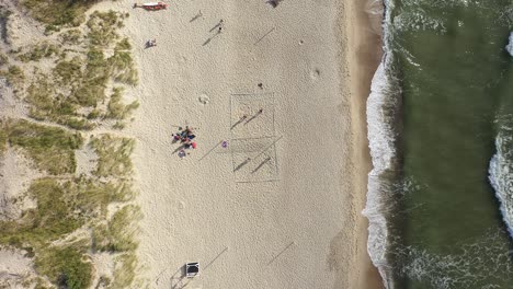 AERIAL:-Young-People-Plays-Volleyball-on-a-Sand-near-Sea-in-Nida