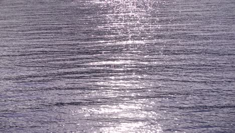 Sparkling-sun-reflections-on-ocean-surface-from-moving-boat---SLOW-MOTION