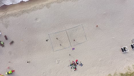 AERIAL:-Rotating-Shot-of-Volleyball-Court-on-a-Sea-Sandy-Beach