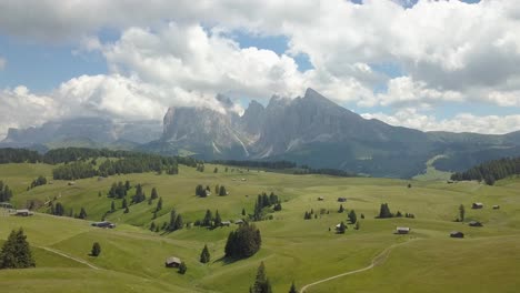 Forward-aerial,-fly-over-Green-Valley-on-a-sunny-Summer-day-in-the-Alpe-di-Siusi,-Seiser-Alm,-Ortisei,-Dolomites,-Italy,-Europe