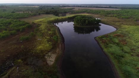 Aerial-video-of-a-small-pond-with-an-island-built-for-duck-hunting-in-Texas