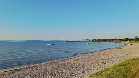 Flying-Over-The-Blue-Calm-Water-By-The-Shore-On-A-Sunny-Day-In-Sandbybadet,-Öland,-Sweden