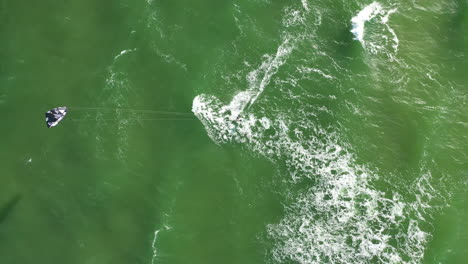 AERIAL:-Top-View-of-Surfer-Riding-Waves-on-a-Green-Colour-Baltic-Sea