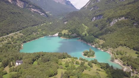 Aerial-of-a-perfect-blue-lake-in-the-middle-of-the-Alps-in-Europe,-Lago-di-Tenno,-Ville-del-monte,-Italia