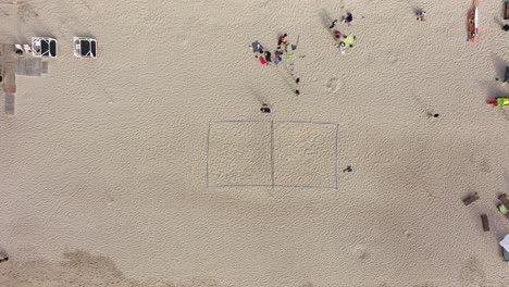 Antenne:-Volleyballfeld-Auf-Sand-Mit-Menschen-Und-Touristen,-Die-Sich-Am-Strand-Ausruhen