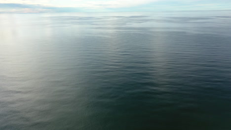 Luftaufnahme:-Rotierende-Aufnahme-Eines-Riesigen-Ozeans-Mit-Blauem-Himmelshorizont