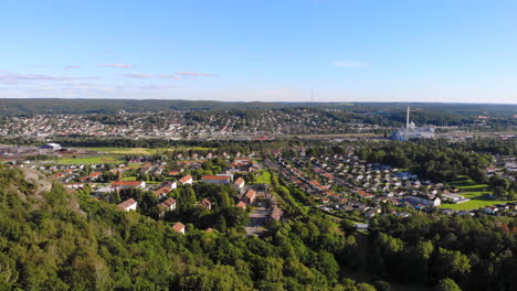 Suburb-Swedish-area-east-of-Gothenburg,-scenic-aerial-drone-view-above-forest-hill,-Sweden,-forward,-day