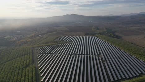 Aerial-view-flying-over-solar-panel-farm-on-a-sunny-day,-the-future-of-green-renewable-energy