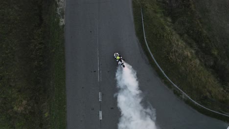 Aerial-top-down-view-of-motorcycle-burning-tire-with-lots-of-smoke