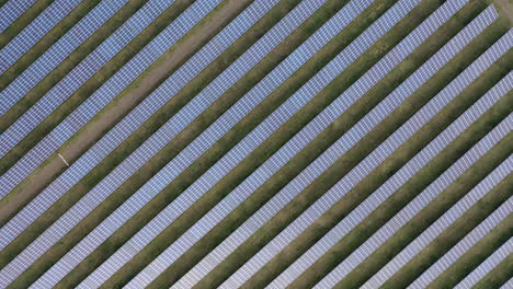 Aerial-drone-view-into-large-solar-panels-at-a-solar-farm-at-bright-sunset