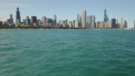 Low-Birds-Eye-View-over-Choppy-Water,-Chicago-Skyline-in-Background