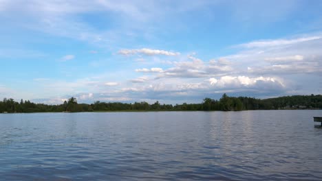 Magnífico-Paisaje-Lacustre---Hermoso-Cielo-Azul-Con-Nubes-Esponjosas-Sobre-Un-Lago-Bordeado-De-árboles---Día-Soleado-De-Verano-60fps