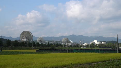 Kumsan-Satellite-Service-Center-on-sunny-day-with-farmland-in-foreground,-static