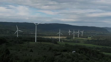 Wind-Turbines-In-A-Row-On-A-Scenic-Field-Landscape-Under-Cloudy-Sky-In-Saint-Lawrence,-Quebec-Canada