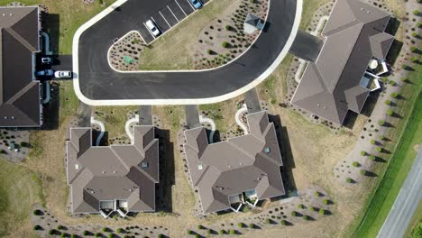 Top-down-aerial-of-houses,-new-scrub-landscaping,-dry-arid-climate,-brown-monochromatic-view-with-hints-of-green-grass