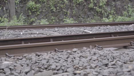 Low-angle-view-of-train-tracks-with-fast-train-passing-by---static-shot