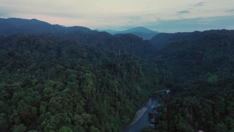 Cinematic-aerial-view-of-Bahorok-River-and-jungle-scenery-from-Bukit-Lawang-village-in-Gunung-Leuser-National-Park,-the-Tropical-Rainforest-Heritage-of-Sumatra,-Indonesia-at-dawn