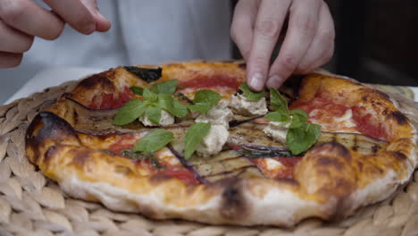 Chef-puts-basil-leaves-on-top-of-neapolitan-pizza