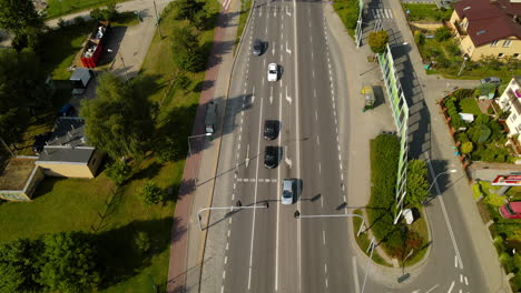 Luftneigung-Nach-Oben-Auf-Grüne-Vorstadtgegend-Mit-Kreuzung-Und-Autos-An-Der-Ampel