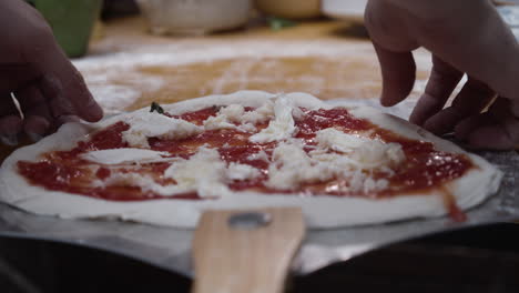 Chef-slides-the-pizza-dough-onto-the-tray-and-stretches-it-to-from-a-circle